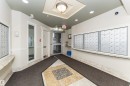 Building entrance featuring a glass door, built-in mailboxes, granite-look countertops, and a decorative ceiling fixture - #219 10333 112 St Nw, Edmonton, AB  - Indoor Photo Showing Other Room 