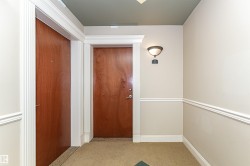 Entryway with wood-finish doors, detailed white trim, and a decorative wall sconce - 
