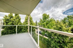 Balcony featuring a textured floor, glass railing, and a slatted ceiling - 