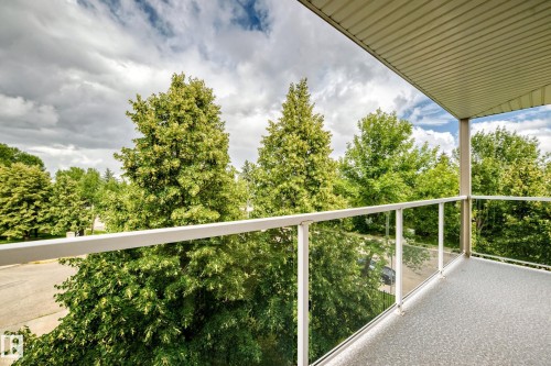 Balcony with glass panel railing, textured flooring, and a slat-paneled ceiling - #331 9704 174 St Nw, Edmonton, AB 