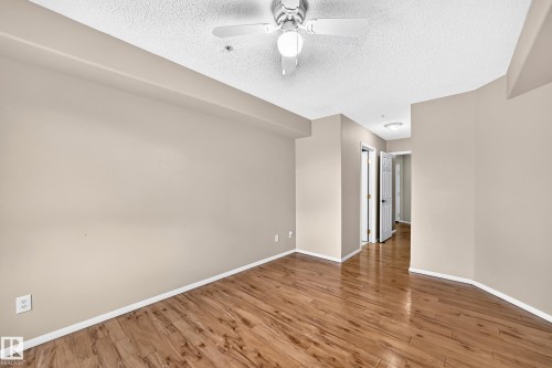 Wood-finish flooring with neutral wall tones and a ceiling fan - #331 9704 174 St Nw, Edmonton, AB 