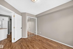 Wood-finish flooring, mirrored closet doors, and neutral wall tones - 