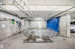 Concrete utility area featuring exposed piping, a hose connection, and floor drainage - 