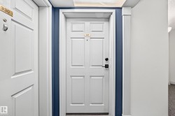 White paneled doors with gold-finish numbering and black hardware - 