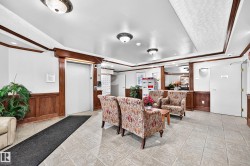 Lobby featuring wood paneling, tile flooring, recessed lighting, and an elevator - 