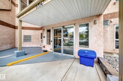 Building exterior featuring textured siding, an extended entry awning, and a glass-paneled entry door - 