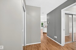 Wood-finish flooring throughout, with white trim and grey walls - 