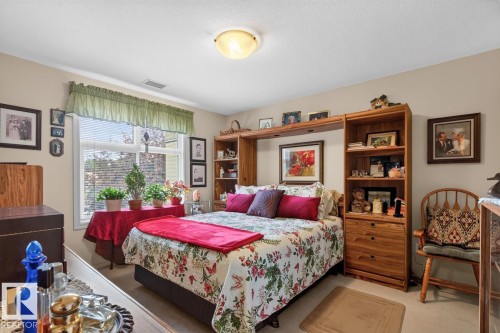 Built-in shelving unit with drawers and open compartments, recessed window with blinds, and ceiling-mounted light fixture - #210 7909 71 St Nw, Edmonton, AB - Indoor Photo Showing Bedroom