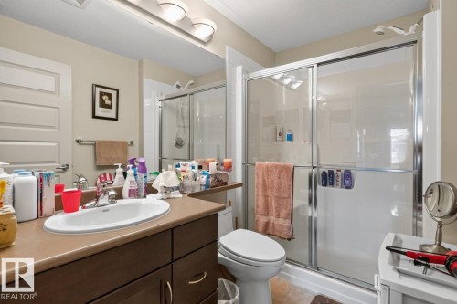 Vanity with an integrated sink, a dark wood-finish cabinet, and a countertop - #210 7909 71 St Nw, Edmonton, AB - Indoor Photo Showing Bathroom
