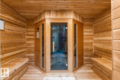 Cedar-lined sauna room featuring built-in wooden benches, natural wood plank walls, and a glass-paneled sauna unit - #210 7909 71 St Nw, Edmonton, AB - Indoor Photo Showing Other Room