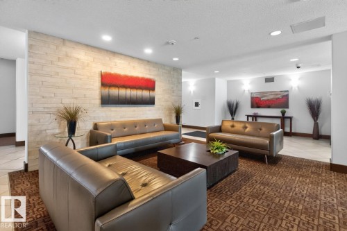 Stacked stone accent wall, recessed lighting, and patterned area rug - #210 7909 71 St Nw, Edmonton, AB - Indoor