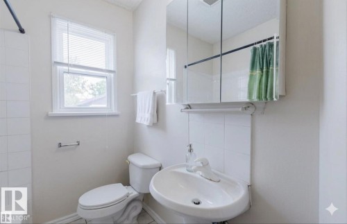 Pedestal sink, wall-mounted mirror cabinet, and tiled shower surround - 12223 127 Street Nw, Edmonton, AB - Indoor Photo Showing Bathroom