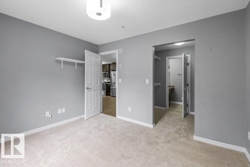 Wall-to-wall carpeting and neutral gray walls - #117 2203 44 Av Nw, Edmonton, AB - Indoor Photo Showing Other Room