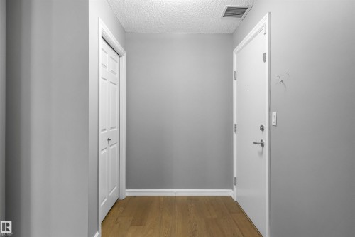 Wood-finish flooring with crisp white trim - #117 2203 44 Av Nw, Edmonton, AB - Indoor Photo Showing Other Room