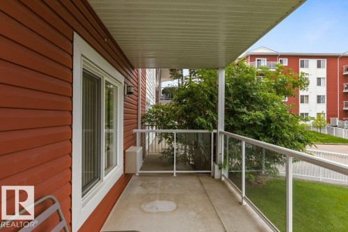 Covered patio with a concrete surface, featuring a glass and aluminum railing - #117 2203 44 Av Nw, Edmonton, AB - Outdoor With Exterior