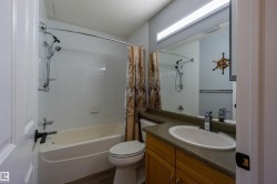 Vanity with integrated sink, wood-finish cabinetry, and solid surface countertop - 