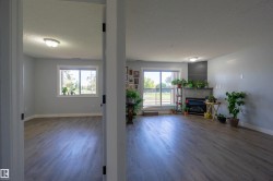 Light gray wall color, wood-finish flooring, and a corner fireplace with a dark tile surround - 
