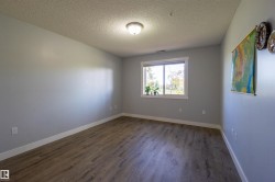 Wood-finish flooring, white baseboards, and a window with white trim - 