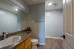 Bathroom vanity with wood-finish cabinetry, integrated sink, and chrome faucet - 