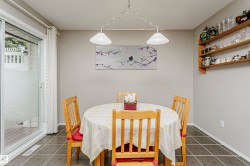 Sliding glass door to an exterior deck, square tile flooring, wood shelving, and a suspended ceiling light fixture - 