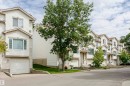 Row of townhomes featuring light-colored siding, multiple windows, and individual garage doors - #42 9630 176 St Nw, Edmonton, AB  - Outdoor With Facade 