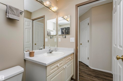 White vanity with integrated sink, chrome faucet, and overhead lighting - #42 9630 176 St Nw, Edmonton, AB - Indoor Photo Showing Bathroom