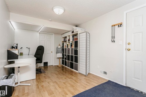 Wood-finish flooring with white walls and a paneled door - #42 9630 176 St Nw, Edmonton, AB - Indoor
