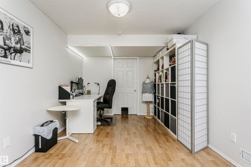 Light wood-finish flooring, white walls, built-in shelving, white paneled door, and recessed lighting - #42 9630 176 St Nw, Edmonton, AB - Indoor Photo Showing Office