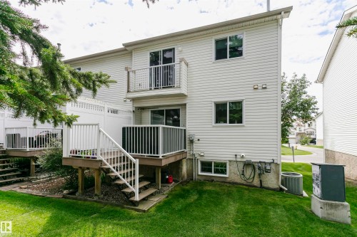 Two-story exterior with white siding, two decks with white railings, and a lower-level window - #42 9630 176 St Nw, Edmonton, AB - Outdoor With Balcony With Deck Patio Veranda With Exterior