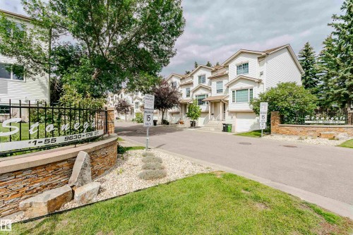 Private property entrance with stone veneer wall, wrought iron fencing, and mature landscaping - #42 9630 176 St Nw, Edmonton, AB - Outdoor