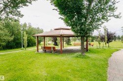 Gazebo with a multi-tiered roof, supported by sturdy posts, featuring a concrete base - 