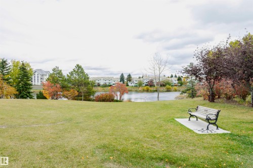 Expansive green space featuring a serene body of water and mature trees - #42 9630 176 St Nw, Edmonton, AB - Outdoor With View