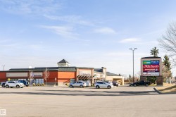 Commercial complex featuring a prominent pylon sign and ample surface parking - 