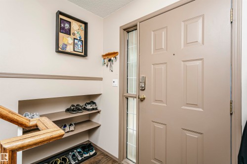 Entry door with sidelight, paneled construction, and brass hardware - #42 9630 176 St Nw, Edmonton, AB - Indoor Photo Showing Other Room