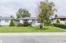 Charming ranch home situated on a mature landscaped lot featuring a sprawling lawn, established trees, and manicured foundation plantings - 11420 46 Avenue Nw, Edmonton, AB  - Outdoor With Facade 