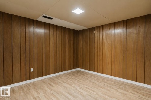 Wood-paneled walls with white trim, wood-finish flooring, and recessed ceiling lighting - 11420 46 Avenue Nw, Edmonton, AB - Indoor Photo Showing Other Room