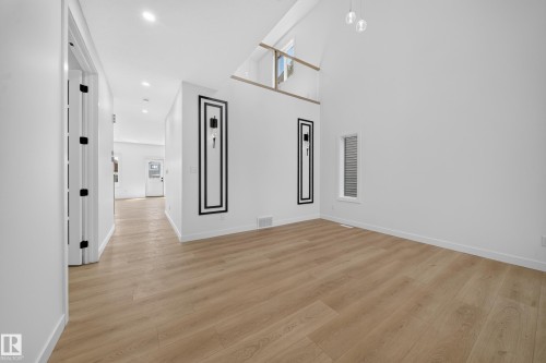 Vaulted ceiling, wood-finish flooring, recessed lighting, and a contemporary pendant light fixture - 8915 Mayday Way Sw, Edmonton, AB - Indoor Photo Showing Other Room