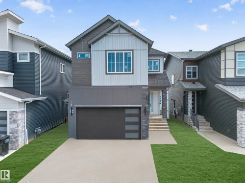 Two-story exterior featuring multi-toned siding, a multi-pane window, and an attached single-car garage - 8915 Mayday Way Sw, Edmonton, AB - Outdoor With Facade