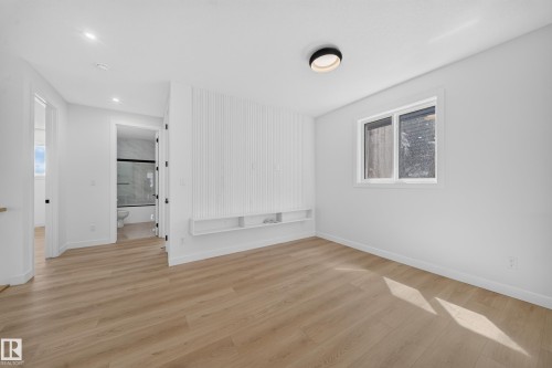 Light wood-finish flooring throughout, white walls, and a recessed window - 8915 Mayday Way Sw, Edmonton, AB - Indoor Photo Showing Other Room