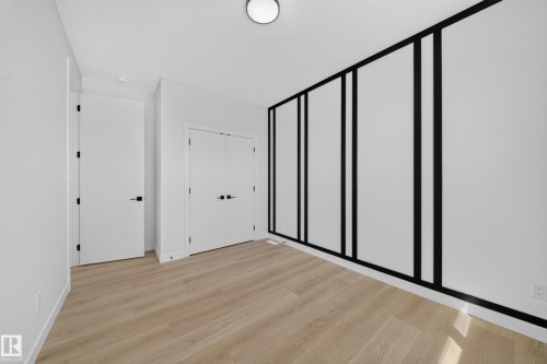 Light wood-finish flooring, white walls, and a recessed ceiling light - 8915 Mayday Way Sw, Edmonton, AB - Indoor Photo Showing Other Room