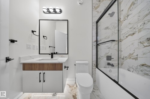 Floating vanity with wood-finish and white cabinetry, a rectangular sink, and a white countertop - 8915 Mayday Way Sw, Edmonton, AB - Indoor Photo Showing Bathroom