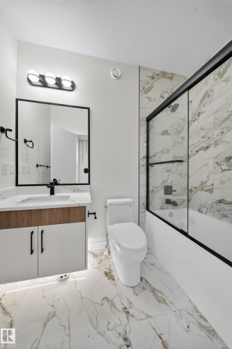Bathroom featuring a built-in vanity with wood-finish and white cabinetry, a rectangular sink, and a black-framed mirror - 8915 Mayday Way Sw, Edmonton, AB - Indoor Photo Showing Bathroom