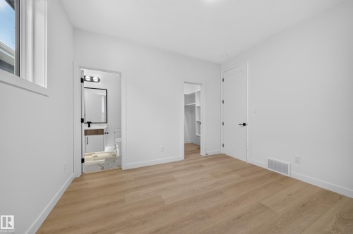 Wood-finish flooring with white walls and trim - 8915 Mayday Way Sw, Edmonton, AB - Indoor Photo Showing Other Room