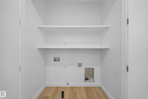 Built-in shelving, wood-finish flooring, and white walls - 8915 Mayday Way Sw, Edmonton, AB - Indoor With Storage