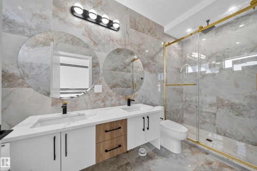 Dual vanity with integrated sinks and white countertops, featuring wood-finish cabinetry - 8915 Mayday Way Sw, Edmonton, AB - Indoor Photo Showing Bathroom
