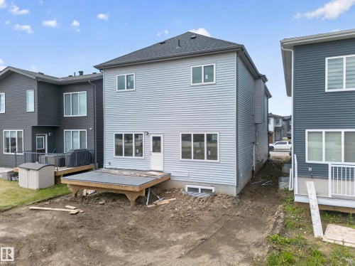 Light gray siding exterior with multiple windows and a rear entry door - 8915 Mayday Way Sw, Edmonton, AB - Outdoor With Deck Patio Veranda With Exterior
