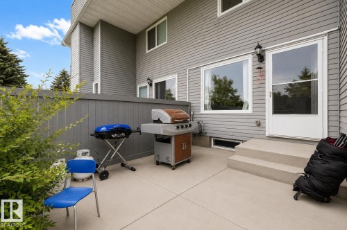 Paved patio area, privacy fence, exterior siding, exterior light fixture, and large windows - #44 1415 62 St Nw, Edmonton, AB - Outdoor With Deck Patio Veranda With Exterior