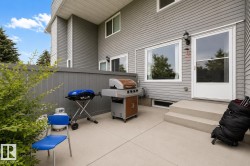Paved patio area, privacy fence, exterior siding, exterior light fixture, and large windows - 