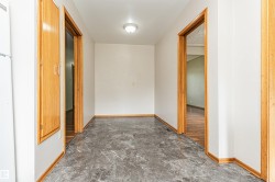 Marble-look flooring, light-toned walls, wooden door frames, and a flush mount ceiling light - 
