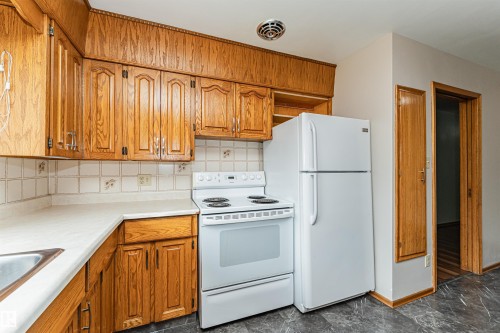 Wood-finish cabinetry paired with white countertops and a tile backsplash - 11139 62 Avenue Nw, Edmonton, AB - Indoor Photo Showing Kitchen